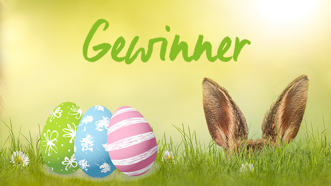 Auf diesem Bild sehen Sie einen Osterhasen der sich im Gras versteckt. Im Bild erkennt man nur seine Ohren. Links daneben liegen drei Ostereier in verschiedenen Farben (Grün, Blau und Rosa)