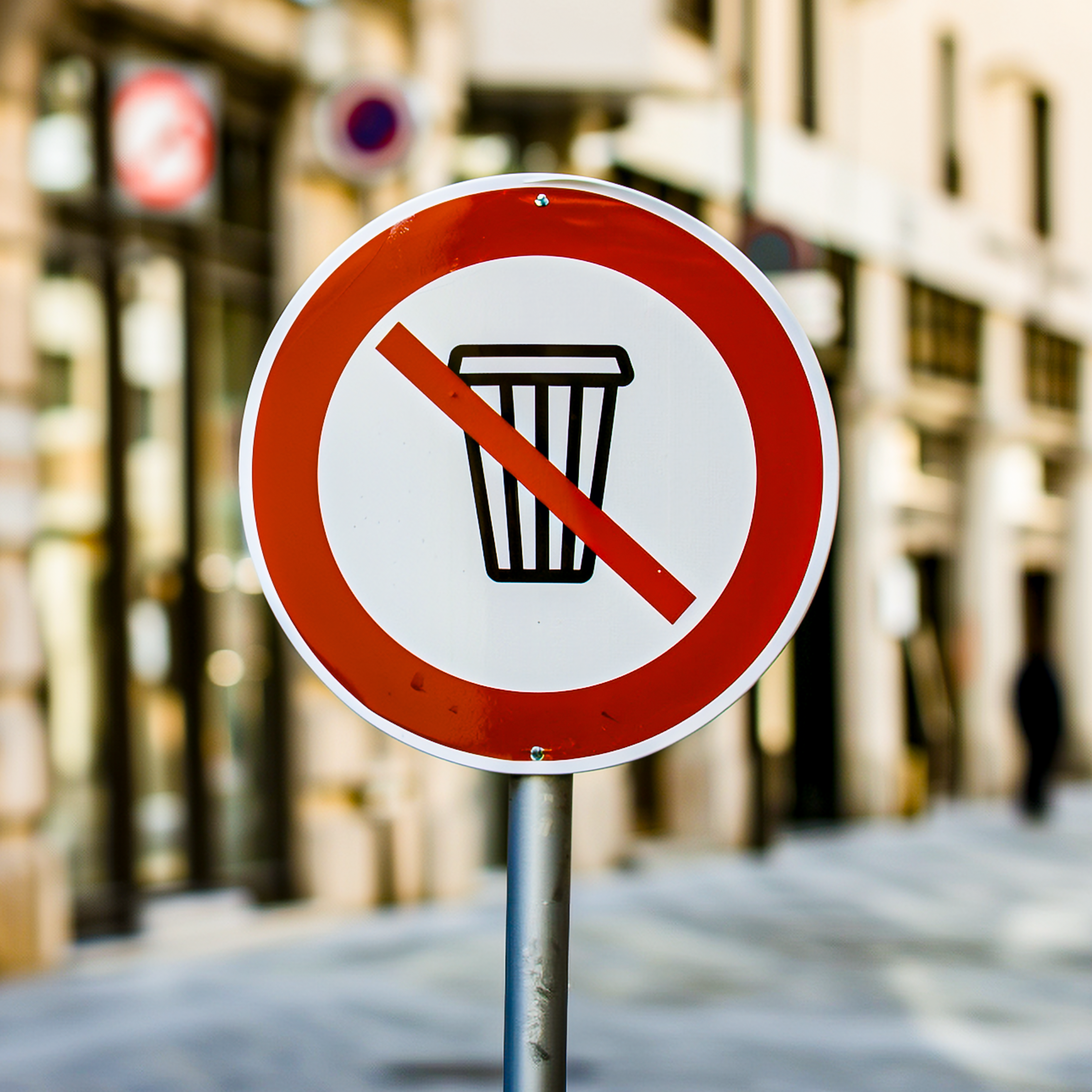 Rundes Verkehrsschild mit rotem Rand und durchgestrichenem Mülleimer-Symbol, das ein Wegwerfen von Abfall an dieser Stelle verbietet.