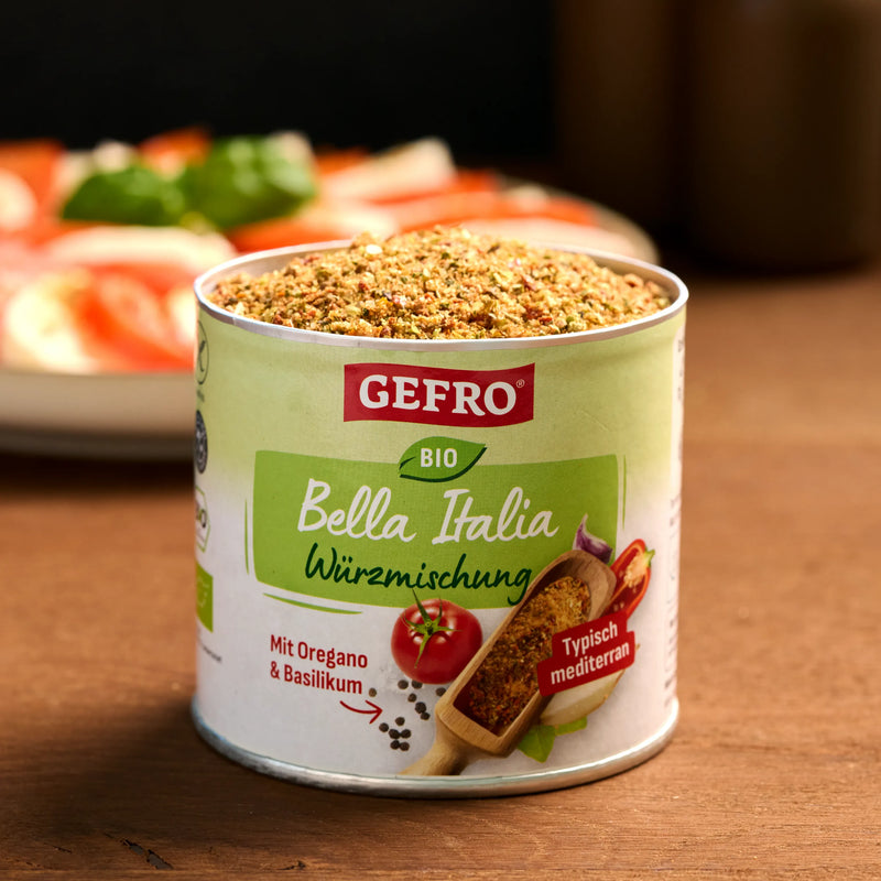 Offene Dose GEFRO Bio Bella Italia Würzmischung auf Holztisch, gefüllt mit mediterranen Kräutern und Gewürzen