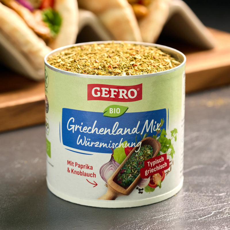 Dose GEFRO Bio Griechenland Mix Würzmischung, geöffnet und gefüllt, vor unscharfem Snack-Hintergrund