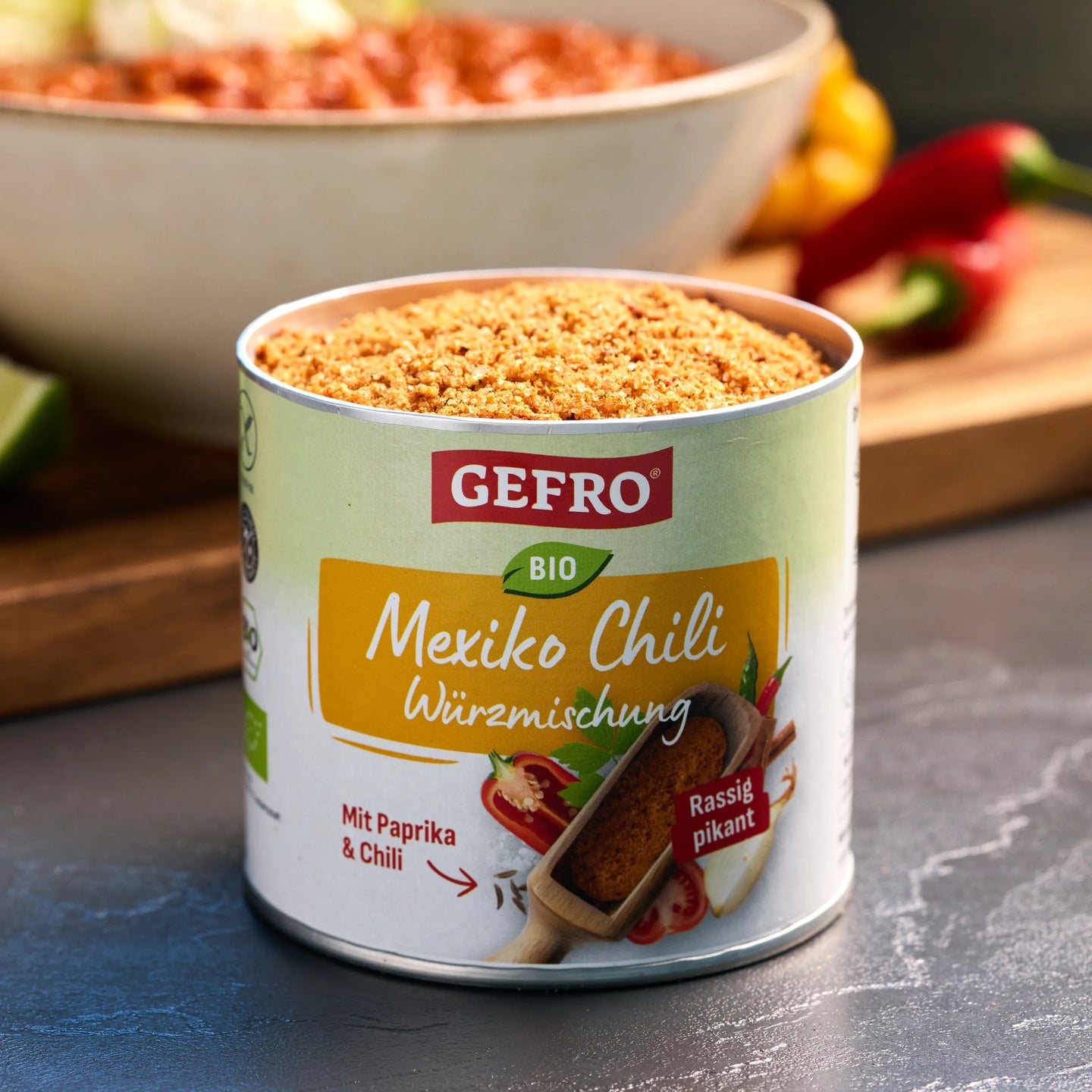 Dose GEFRO Bio Mexiko Chili Würzmischung mit geöffnetem Inhalt, davor arrangiert für würzige Chili-Gerichte.