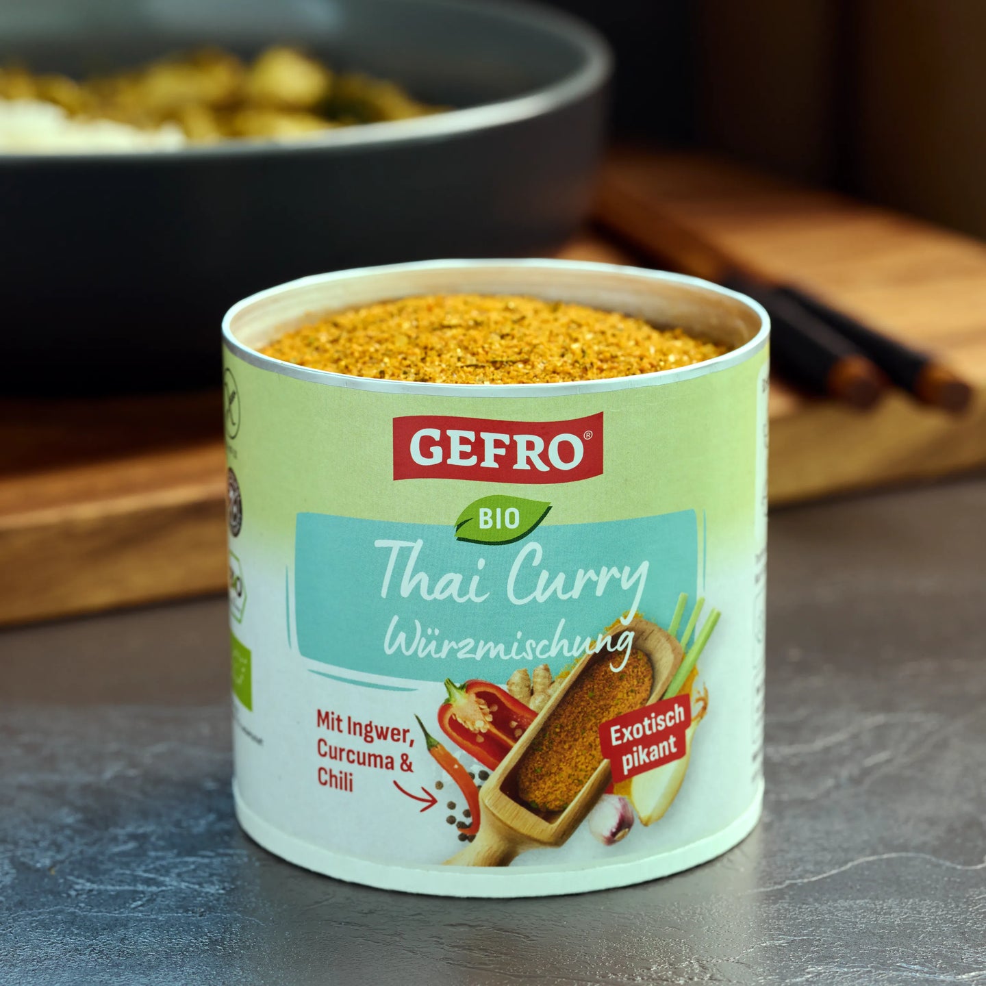 Dose mit GEFRO Bio Thai Curry Würzmischung auf einer Küchenfläche, geöffnet und gefüllt mit gelbem Gewürzpulver