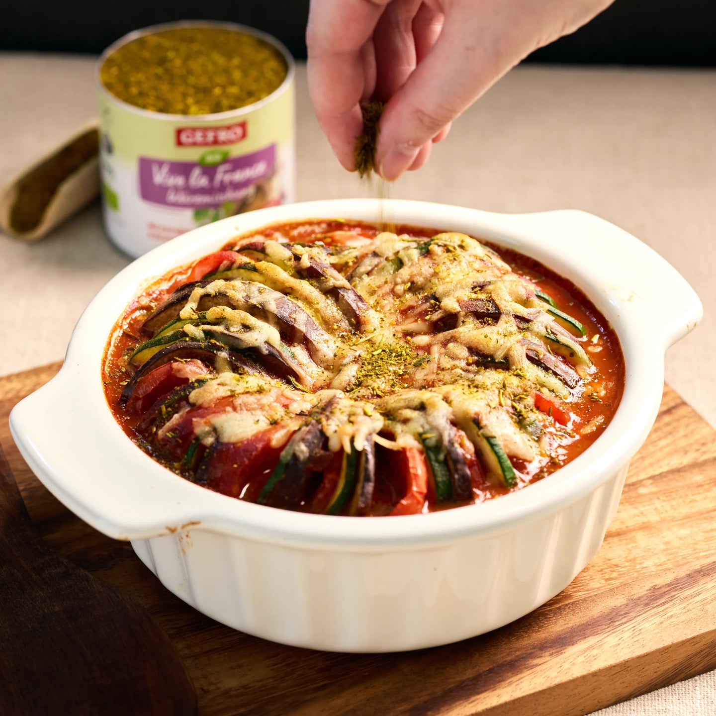 Auflauf mit Tomaten, Zucchini und Auberginen in roter Sauce, mit Käse überbacken und mit Kräutern bestreut