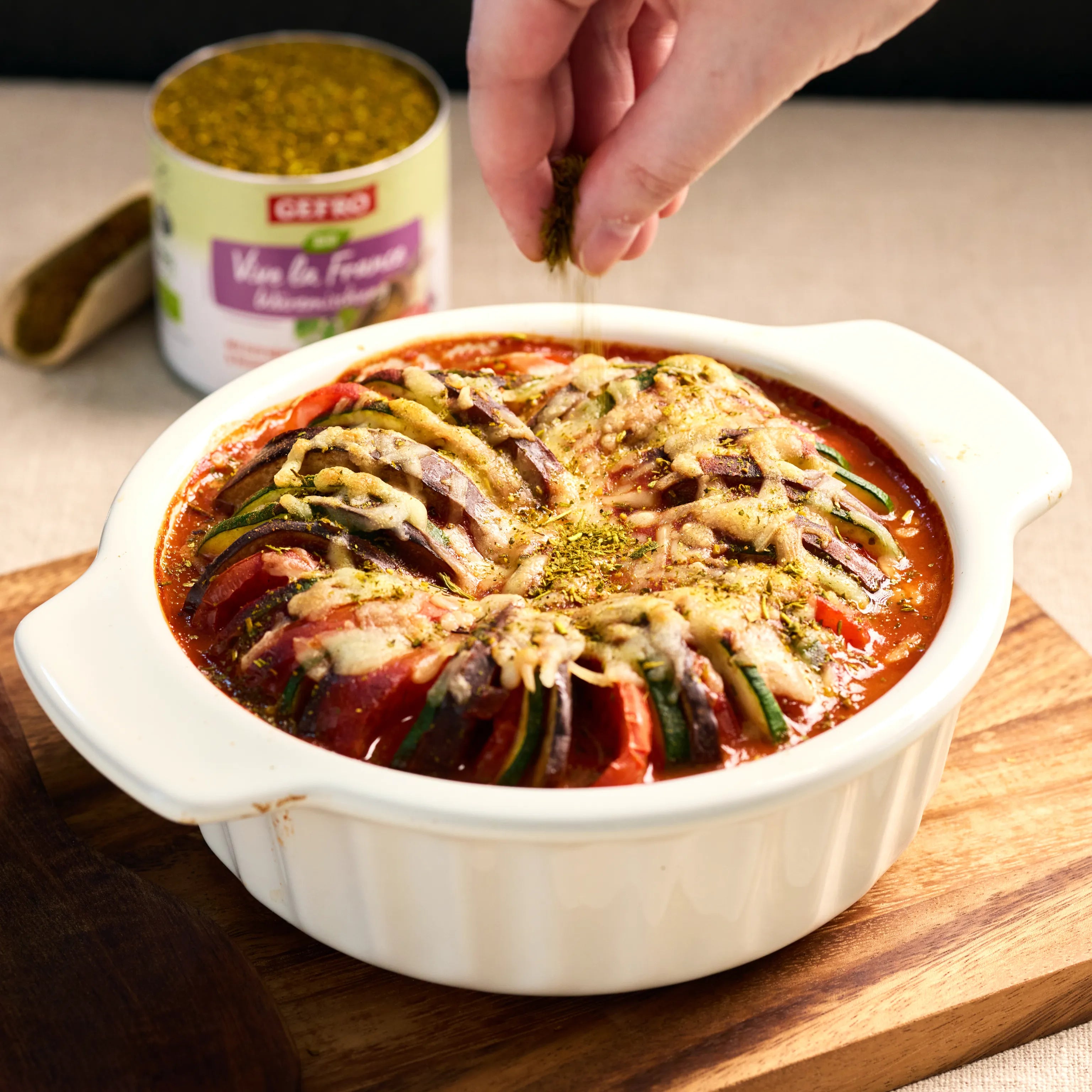 Auflauf mit Tomaten, Zucchini und Auberginen in roter Sauce, mit Käse überbacken und mit Kräutern bestreut
