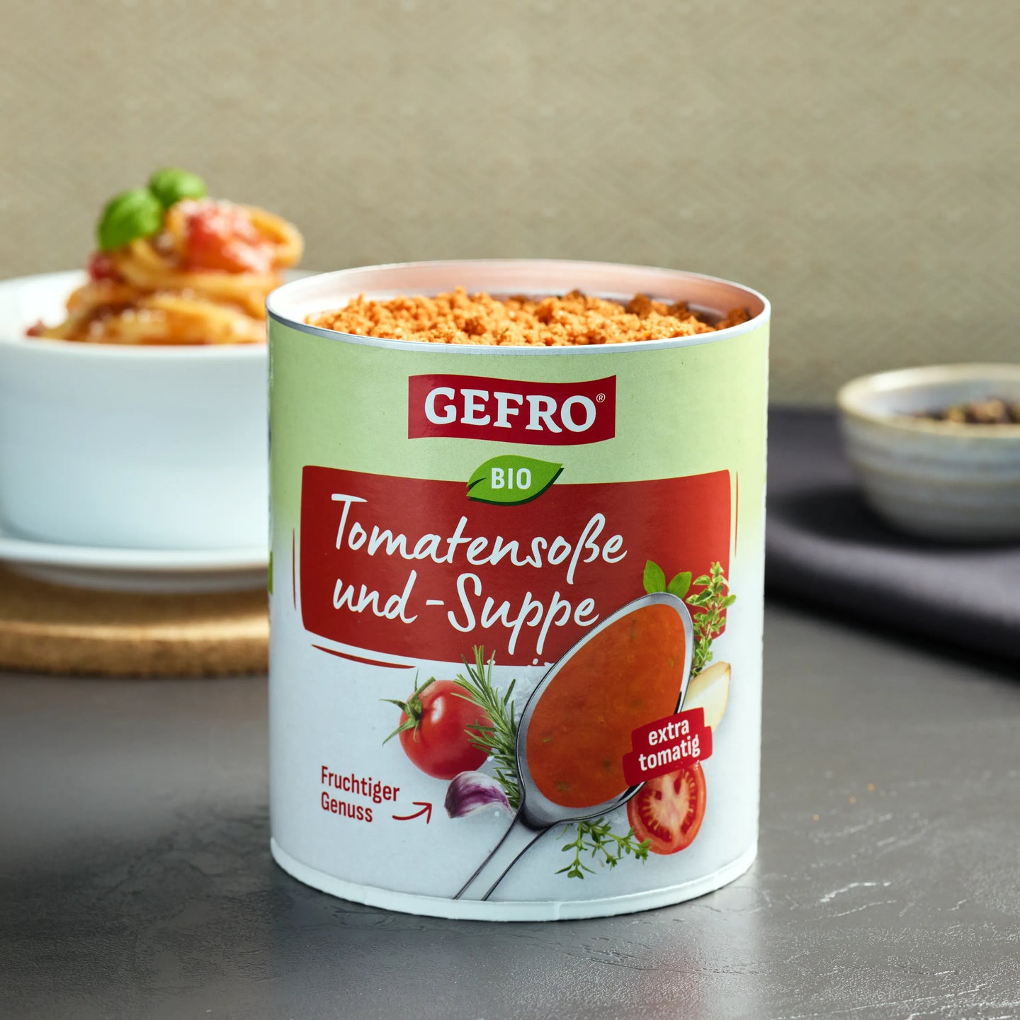 Dose GEFRO Bio Tomatensoße und -Suppe auf Tisch, geöffnet mit Pulver, davor Produktetikett gut sichtbar