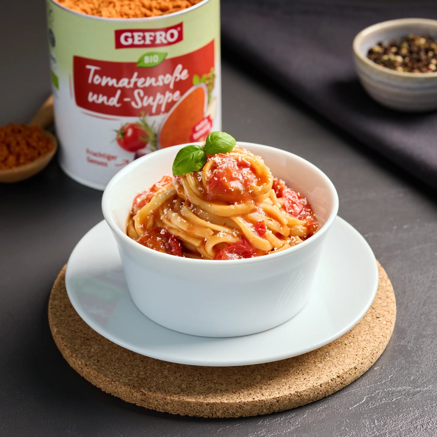 Schale mit Pasta in Tomatensoße, garniert mit Basilikum; daneben Dose GEFRO Bio Tomatensoße und -Suppe.