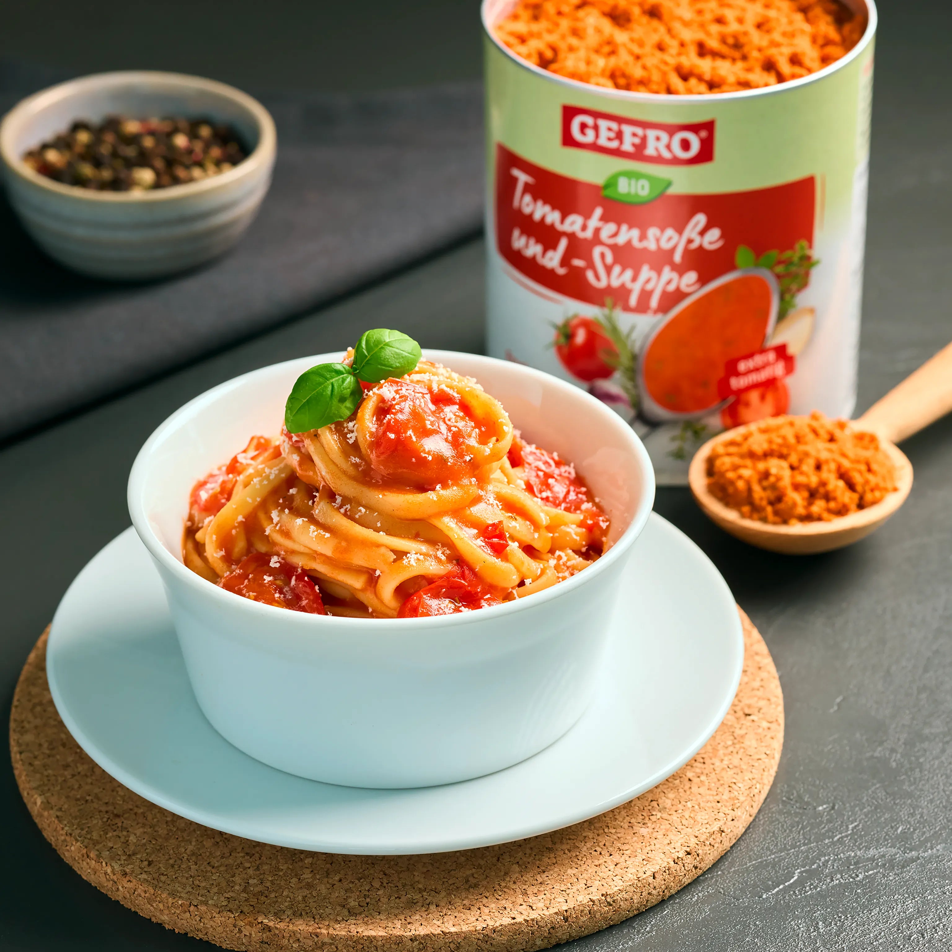 Schüssel mit Pasta in Tomatensoße, garniert mit Basilikum; daneben Dose GEFRO Bio Tomatensoße und Suppe.