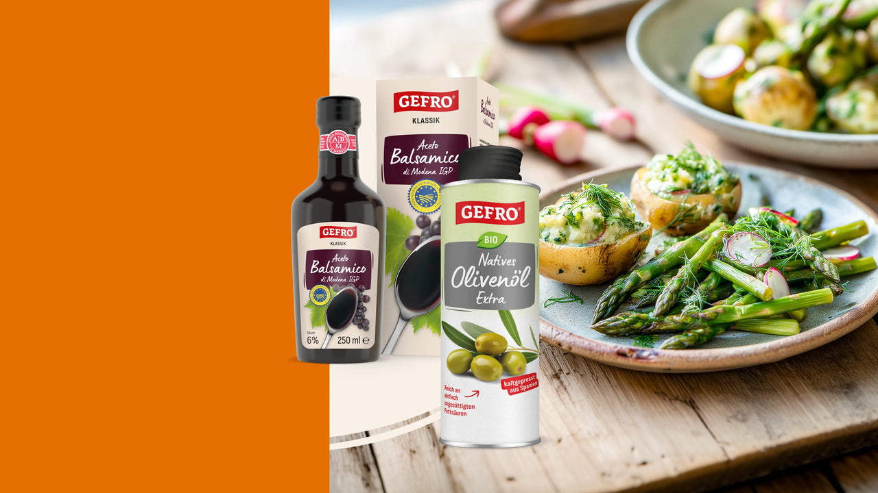 GEFRO Aceto Balsamico und natives Olivenöl extra neben Spargel und gefüllten Kartoffeln auf Holztisch