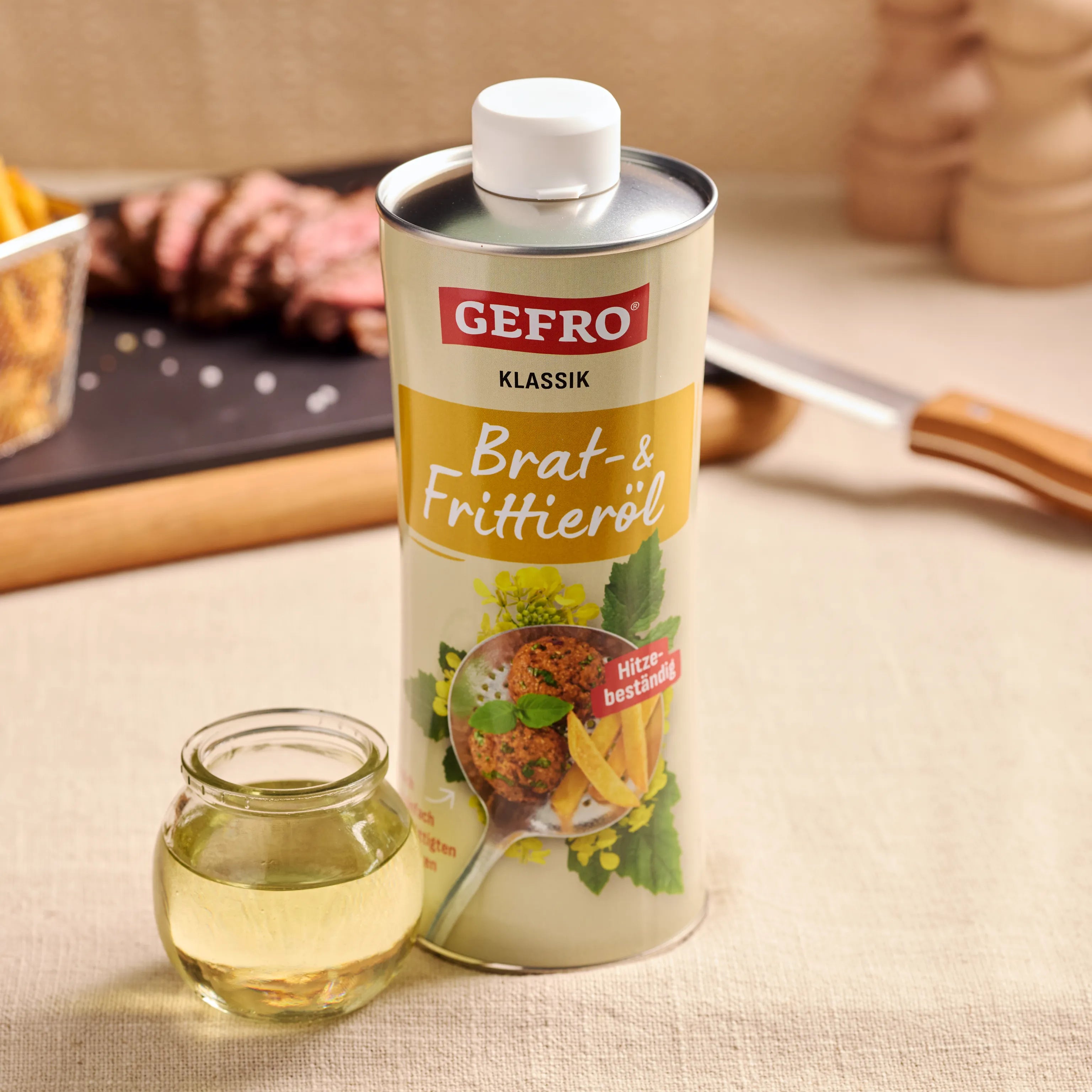 Gefro Klassik Brat- und Frittieröl in Dose mit kleinem Glas Öl auf Küchentisch, passend zum Braten und Frittieren