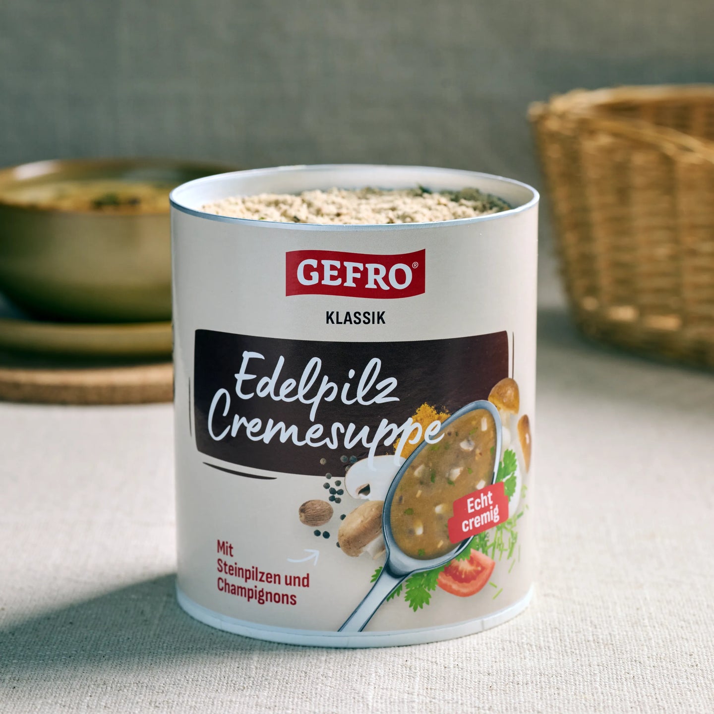 Dose Gefro Klassik Edelpilz Cremesuppe, geöffnet und gefüllt, auf Tisch mit unscharfem Küchenhintergrund.