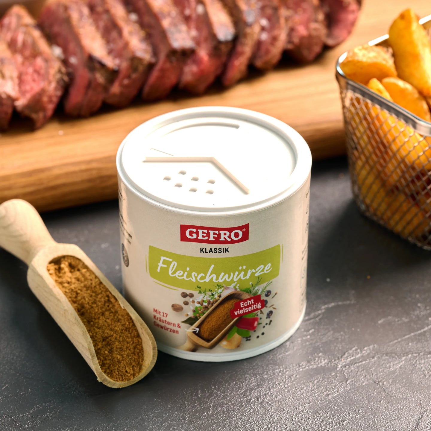 GEFRO Klassik Fleischwürze in Dose mit Gewürzlöffel, vor gegrilltem Steak und Pommes als Einsatz beim Würzen von Fleisch