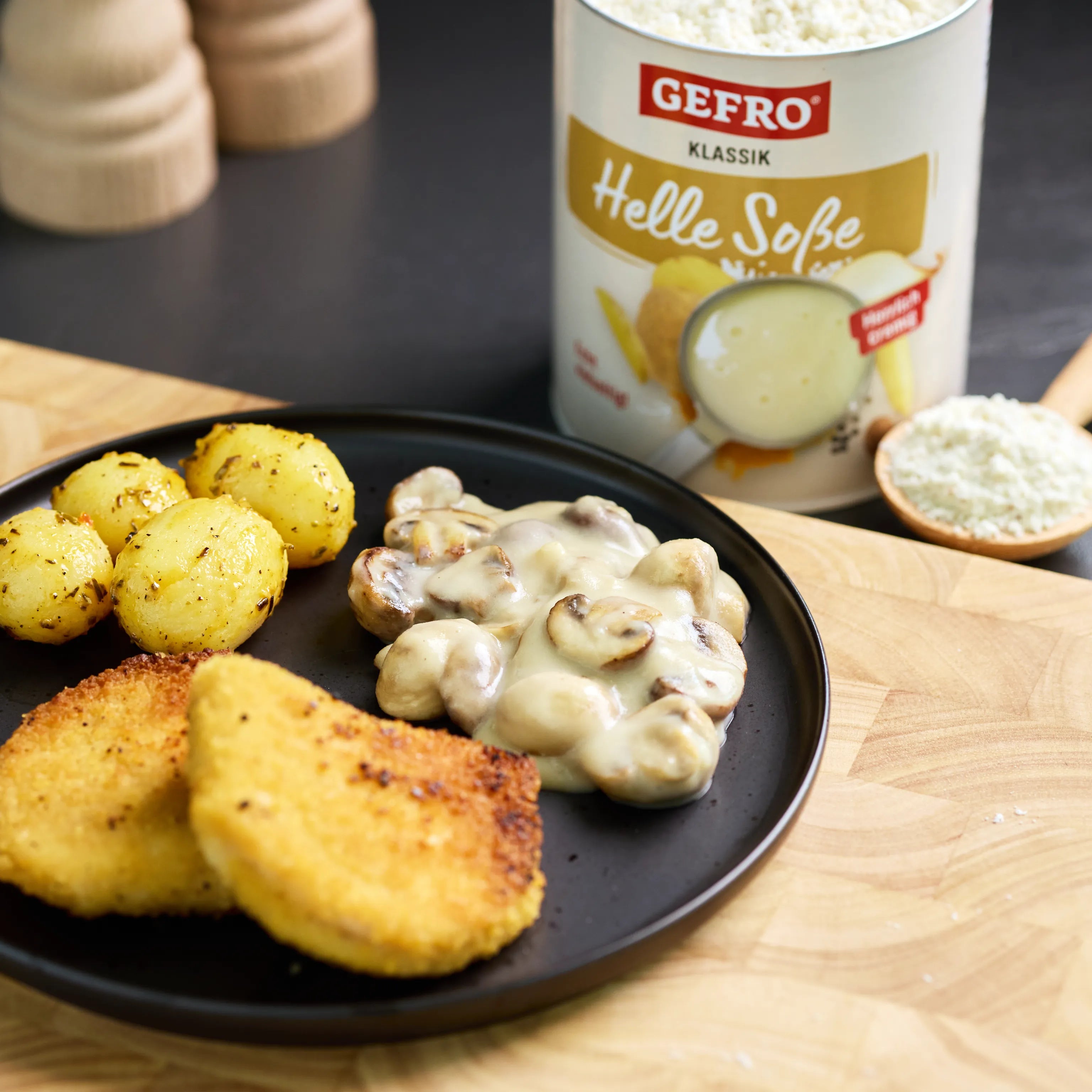 Panierte Schnitzel mit Kartoffeln und Champignons in heller Soße, daneben eine Dose GEFRO Helle Soße Klassik.