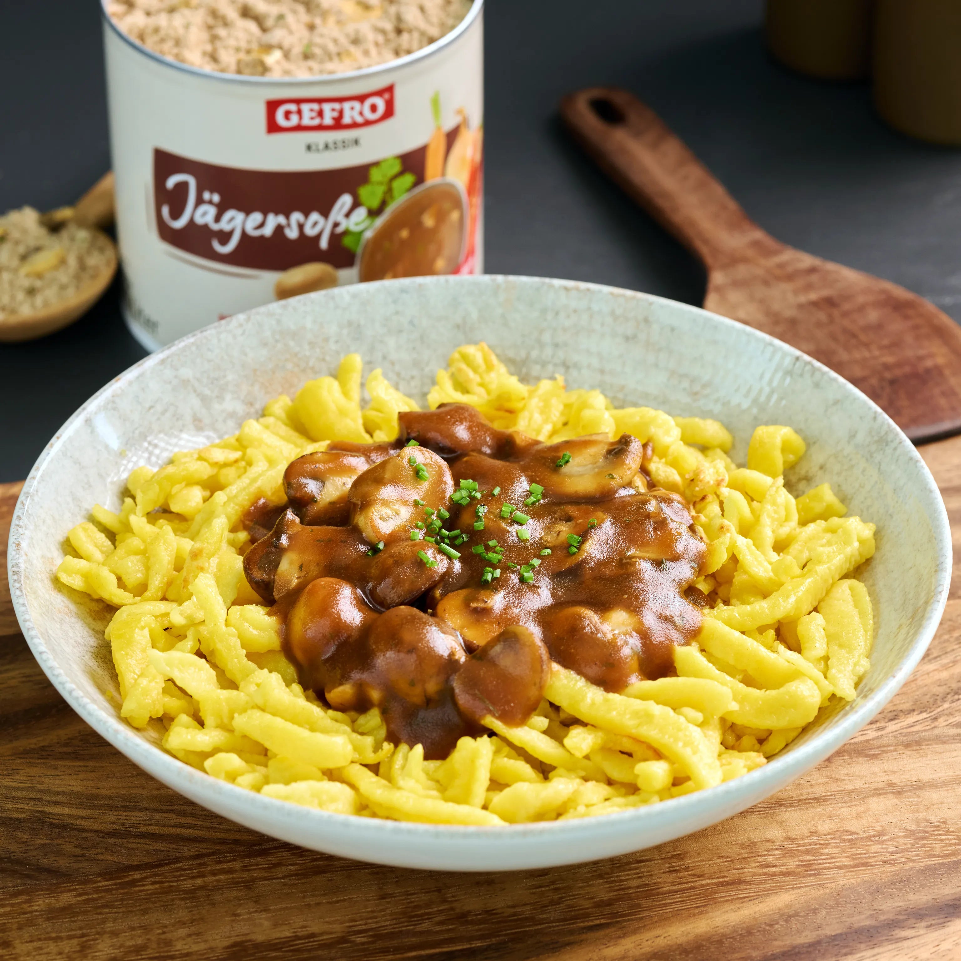 Schüssel mit Spätzle und brauner Jägersoße mit Champignons, dahinter eine geöffnete Dose Gefro Jägersoße.