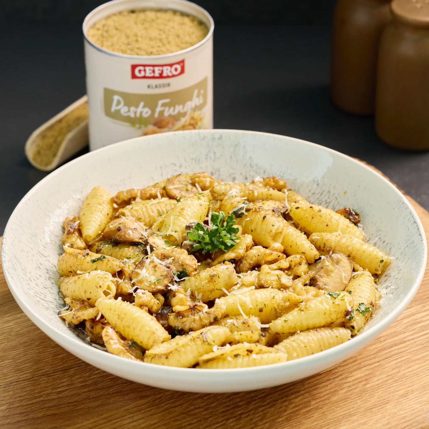 Schale mit Pasta in cremiger Pilz-Pesto-Sauce, mit Walnüssen, Pilzen und geriebenem Käse serviert.