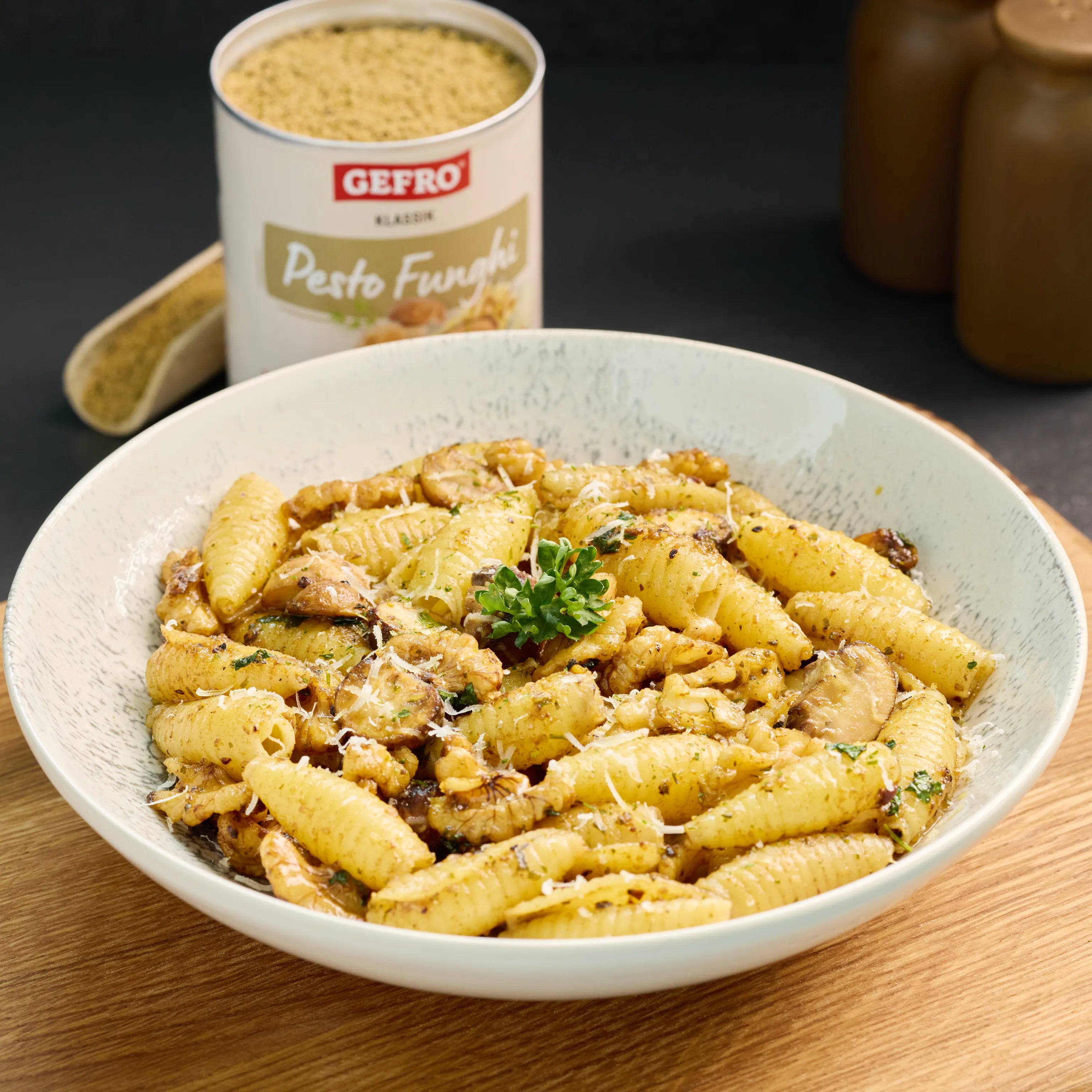 Schale mit Pasta in cremiger Pilz-Pesto-Sauce, mit Walnüssen, Pilzen und geriebenem Käse serviert.