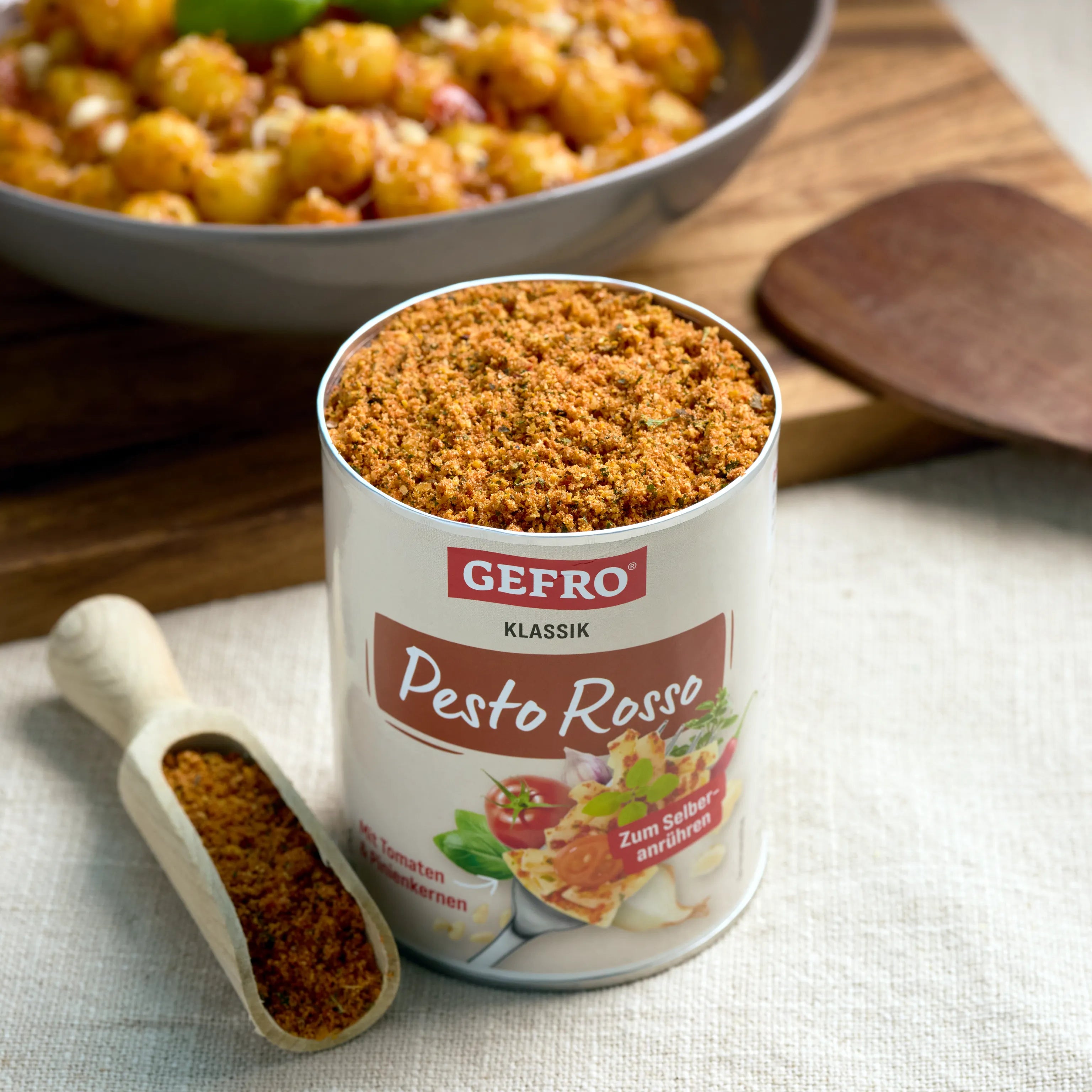 Dose GEFRO Pesto Rosso Klassik mit Gewürzmischung zum Selbstanrühren, daneben Holzschaufel mit Pulver.