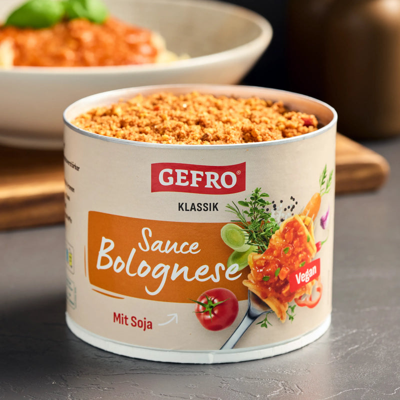 Dose GEFRO Klassik Sauce Bolognese mit Soja, vegan, geöffnet auf Tisch, im Hintergrund ein Teller mit Pasta