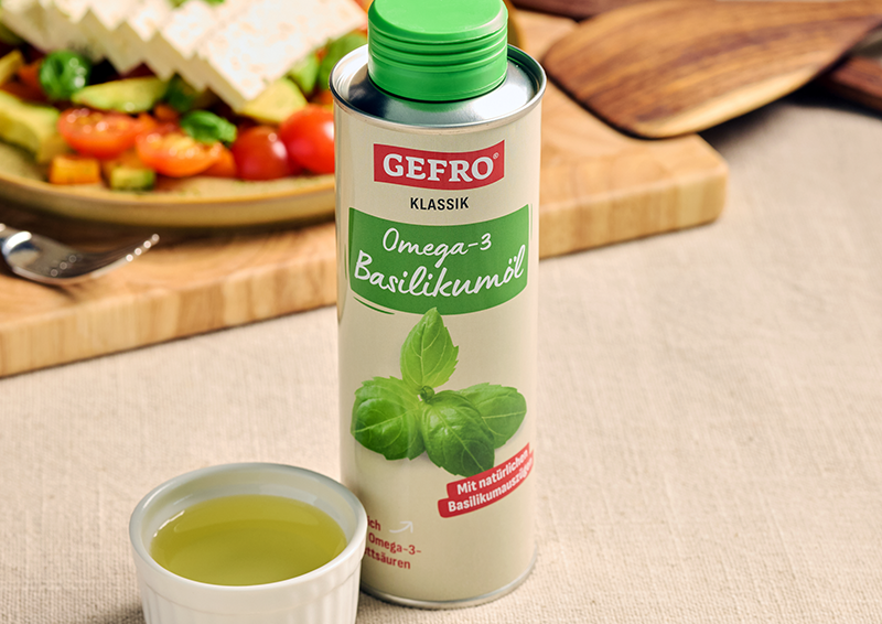 Gefro Klassik Omega-3 Basilikumöl in Flasche mit grünem Deckel, daneben eine kleine Schale mit Öl.