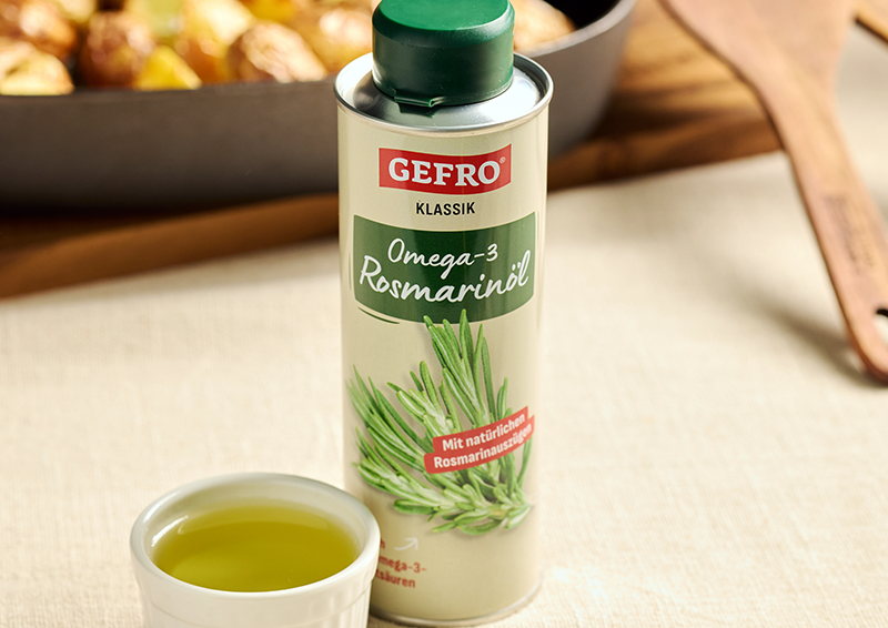 Dose GEFRO Omega-3 Rosmarinöl neben kleinem Schälchen mit Öl auf einem Tisch in der Küche