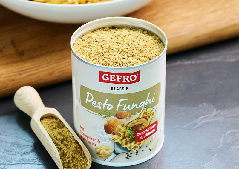 Dose mit GEFRO Pesto Funghi Pulver, daneben Holzschaufel mit Inhalt, präsentiert als Würzmischung für Pasta