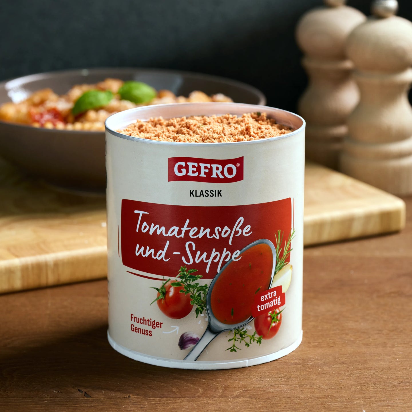 Dose GEFRO Klassik Tomatensoße und -Suppe auf Holztisch, geöffnet vor einem Teller Pasta in der Küche