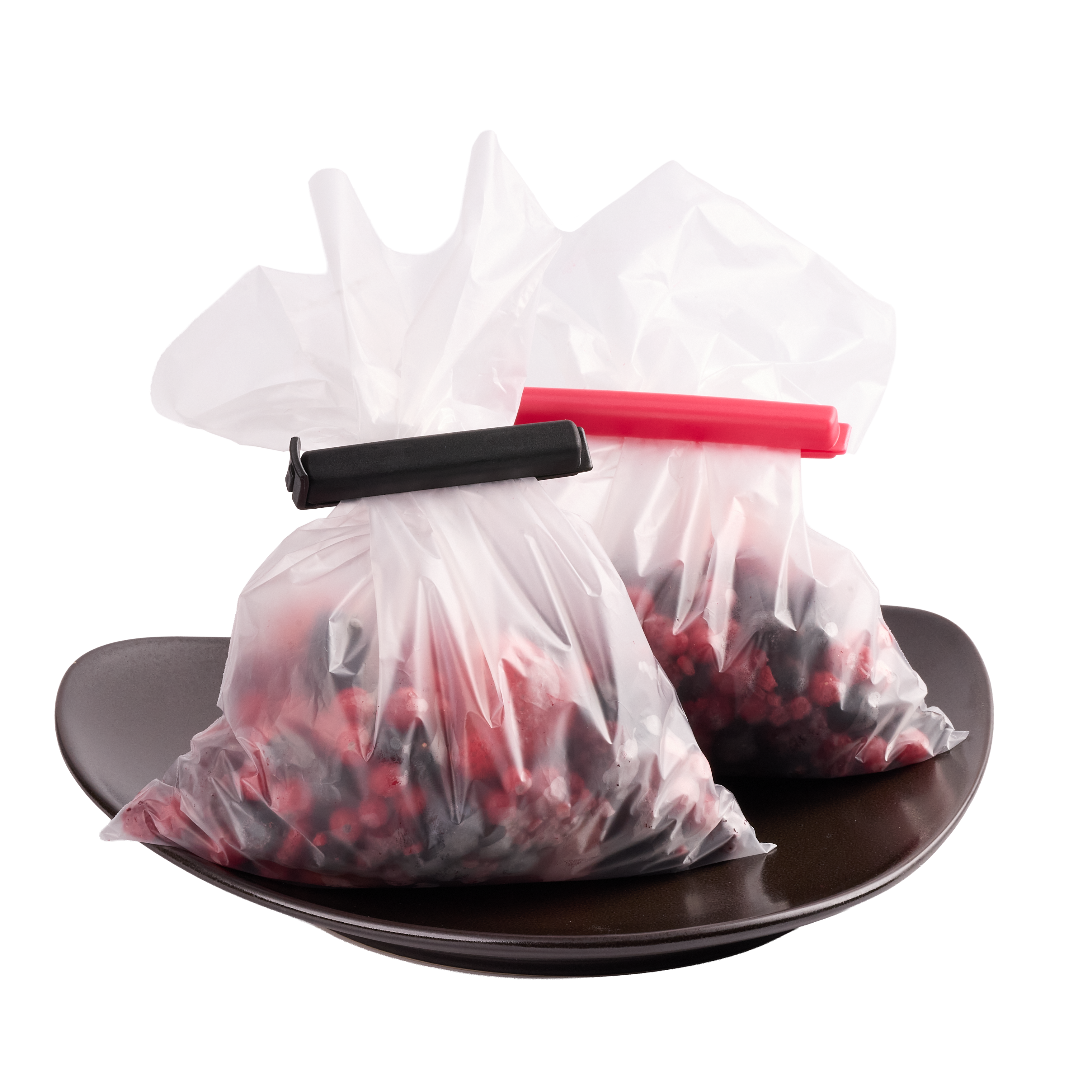 Zwei transparente Gefrierbeutel mit Beeren auf einem Teller, verschlossen mit farbigen Beutelclips zur Aufbewahrung