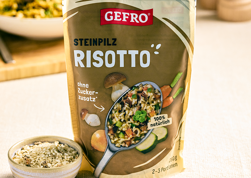 Verpackung von Gefro Steinpilz-Risotto mit Löffelbild, Pilzen und Gemüse, vorne auf einem Tisch platziert