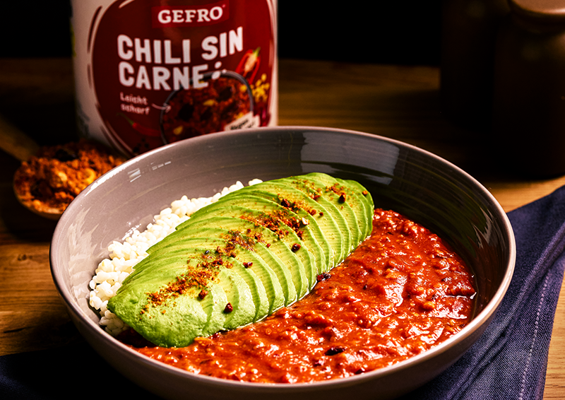 Schüssel mit Chili sin Carne, Reis und fächerförmig geschnittener Avocado, daneben Produktdose von Gefro
