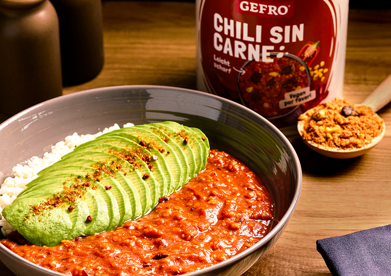 Schüssel mit Chili sin Carne, Reis und Avocadoscheiben; daneben GEFRO Dose und ein Löffel Gewürzmischung