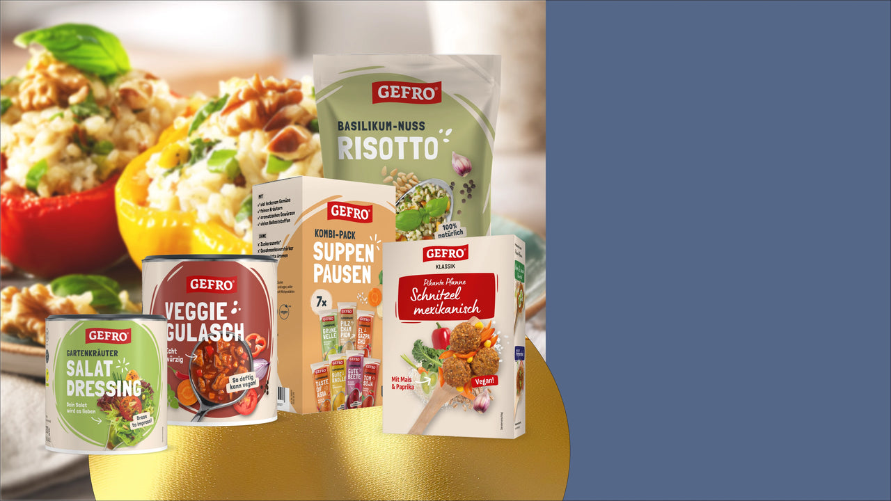GEFRO-Produkte wie Risotto, Veggie-Gulasch, Salat-Dressing und Suppen-Packung vor gefüllten Paprikaschoten arrangiert