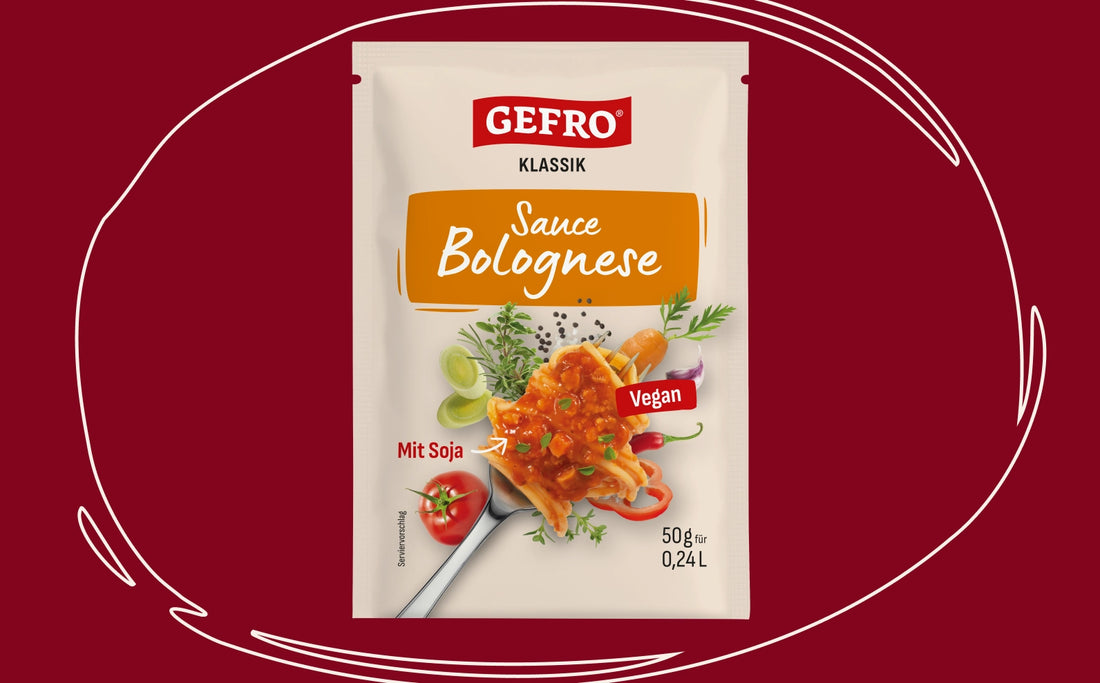 Packung „GEFRO Klassik Sauce Bolognese“ (vegan, mit Soja) auf rotem Hintergrund, umrahmt von einer weißen, skizzenhaften Kreislinie; abgebildet ist ein Teller mit Pasta und Bolognese-Sauce sowie Gemüse.