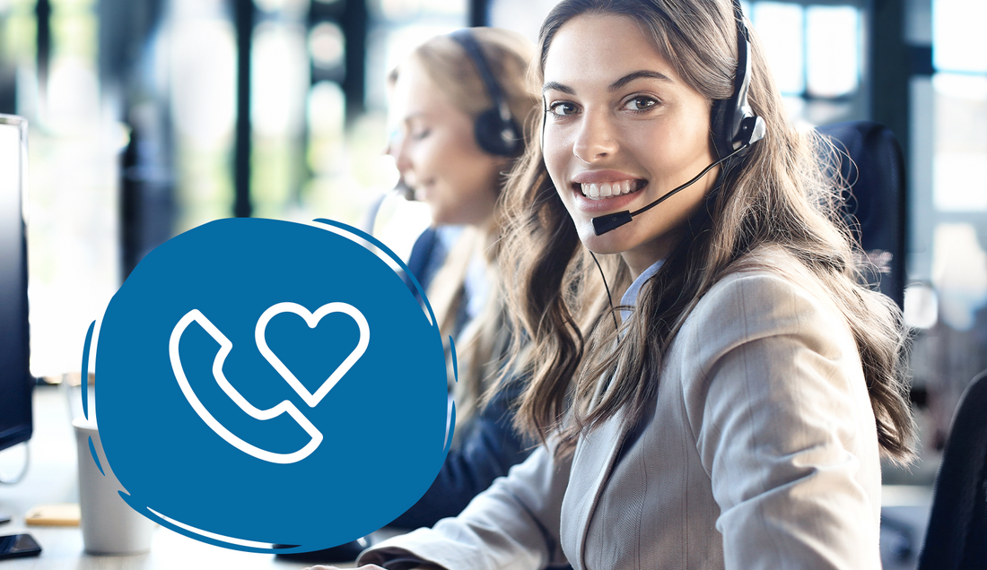 Lächelnde Mitarbeiterin mit Headset im Kundenservice-Büro, dazu Symbol mit Telefonhörer und Herz für Hilfe und Beratung