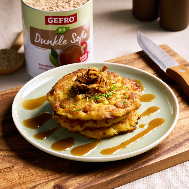 Drei goldbraune Kartoffelpuffer mit Soße, Röstzwiebeln und Schnittlauch auf einem Teller, daneben GEFRO Dunkle Soße.