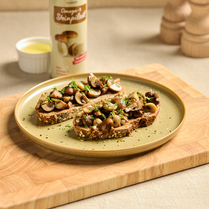 Drei Brote mit gebratenen Pilzen und Kräutern auf einem Teller, daneben Omega-3-Speiseöl im Hintergrund