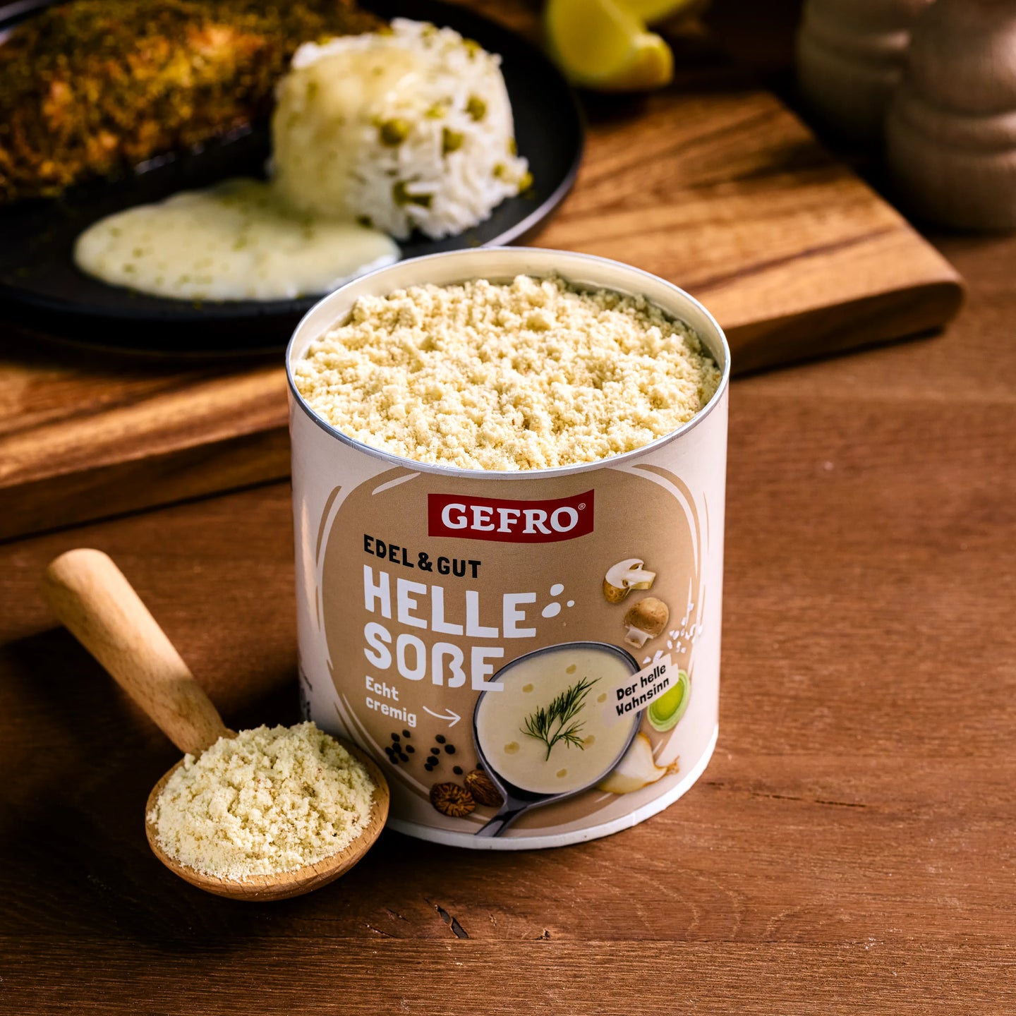 Dose GEFRO Helle Soße mit Pulver und Holzlöffel auf Tisch, im Hintergrund serviertes Gericht mit Reis und Soße