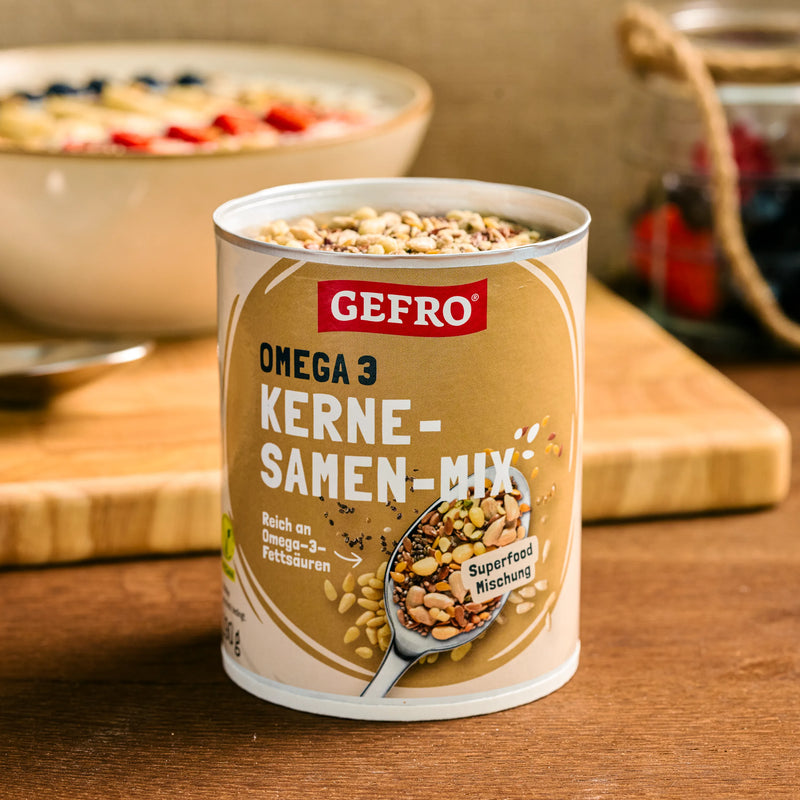 Dose mit GEFRO Omega 3 Kerne-Samen-Mix auf Holztisch, geöffnet und servierbereit in einer Küchenszene
