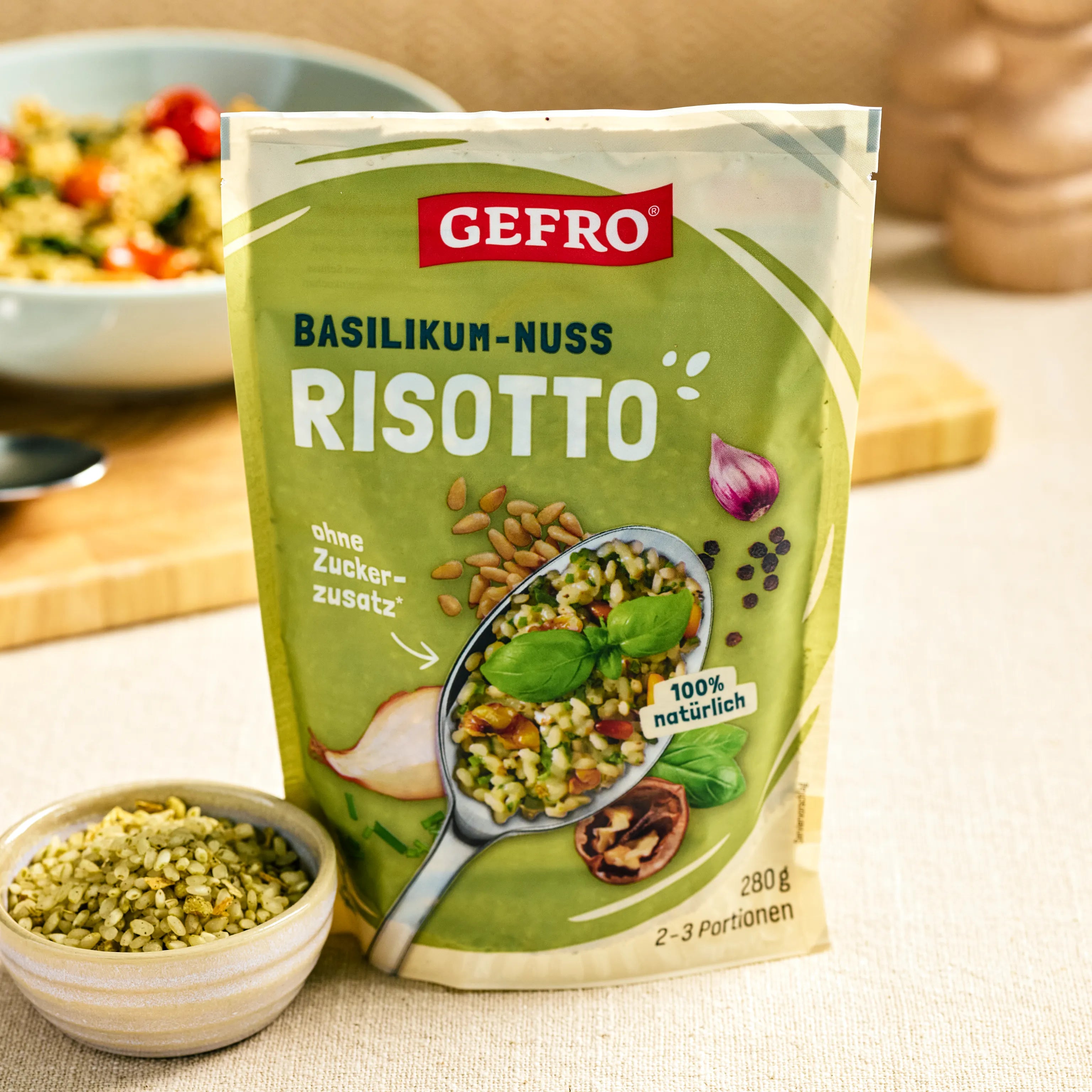 Verpackung von GEFRO Basilikum-Nuss Risotto, 280 g, mit Schale Risotto im Vordergrund auf hellem Küchentisch