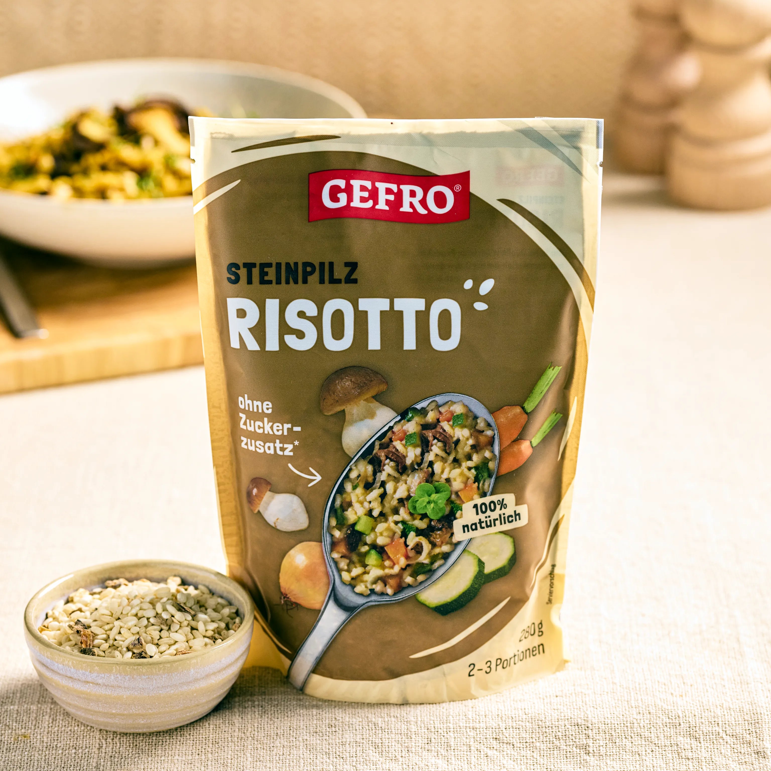 Verpackung von GEFRO Steinpilz-Risotto auf einem Tisch, daneben eine Schale mit Reismischung, 2–3 Portionen