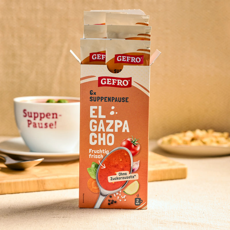 Offene Packung GEFRO Suppenpause El Gazpacho mit Portionsbeuteln, davor Produktbild auf einem Küchentisch