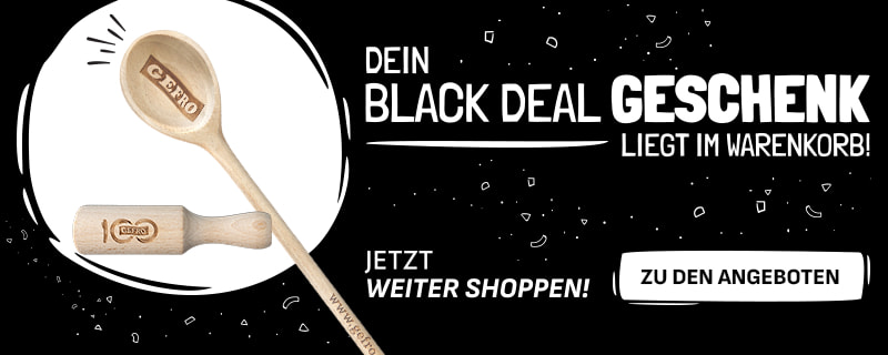 Werbebanner mit schwarzem Hintergrund und weißer Schrift: „Dein Black Deal Geschenk liegt im Warenkorb! Jetzt weiter shoppen!“. Links sind ein hölzerner Kochlöffel mit Gravur „GEFRO“ und ein hölzernes Nudelholz mit Jubiläumsgravur abgebildet. Rechts ein weißer Button mit der Aufschrift „Zu den Angeboten“