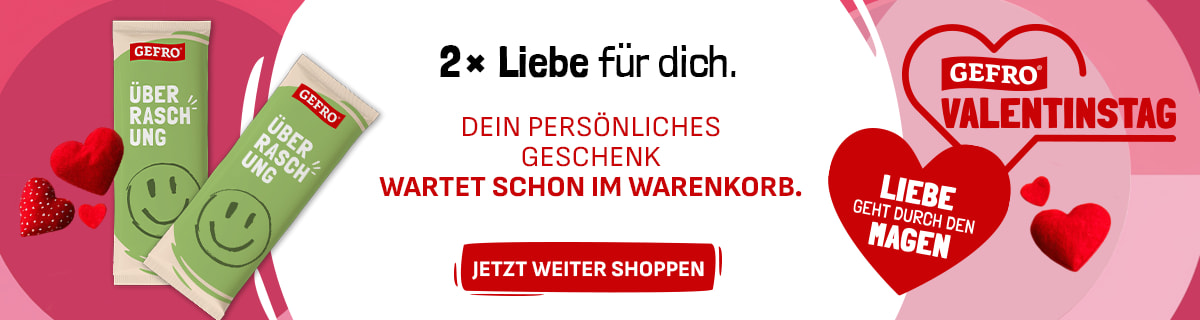Zwei grüne Gefro-Überraschungsprodukte mit Smiley vor rosa Hintergrund. Textlicher Hinweis, dass ein persönliches Geschenk im Warenkorb bereitliegt. Valentinstagsmotiv mit Herzsymbol und Gefro-Logo.