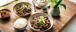 Gewokte Pilze mit Frühlingslauch und jungen Karotten