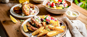 Bifteki mit Kartoffel-Wedges und griechischem Salat