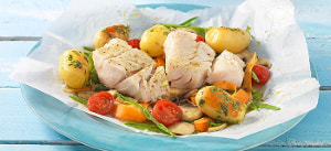 Kabeljaufilet und Frühlingsgemüse im Papier gegart